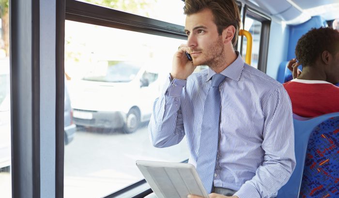 Businessman Using Mobile Phone And Digital Tablet On Bus