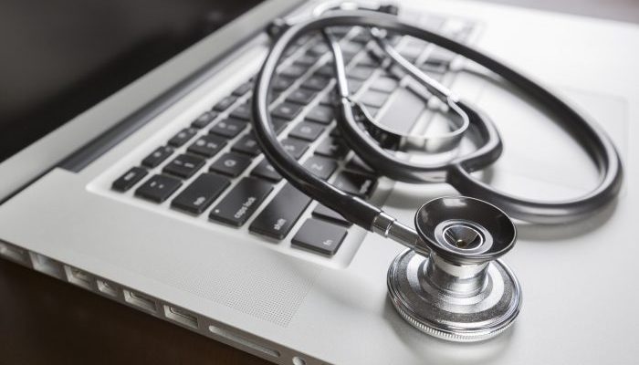 Medical Stethoscope Resting on Laptop Computer Keyboard.