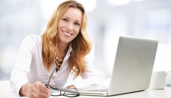 Close-up ortrait of executive business woman with laptop working on presentation.