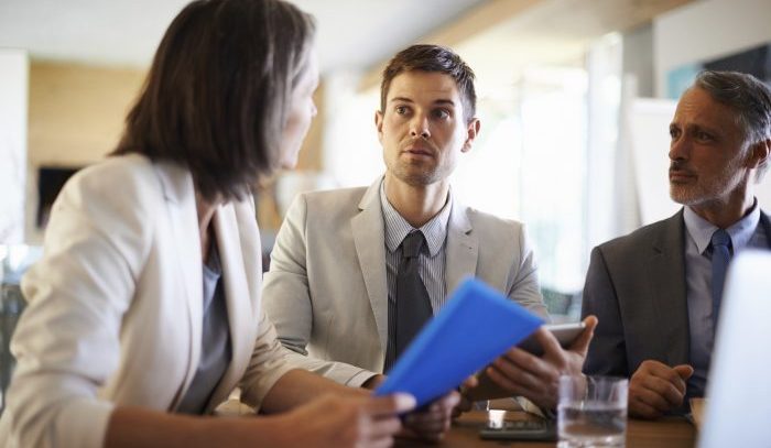 Three serious-looking businesspeople having a meeting at work