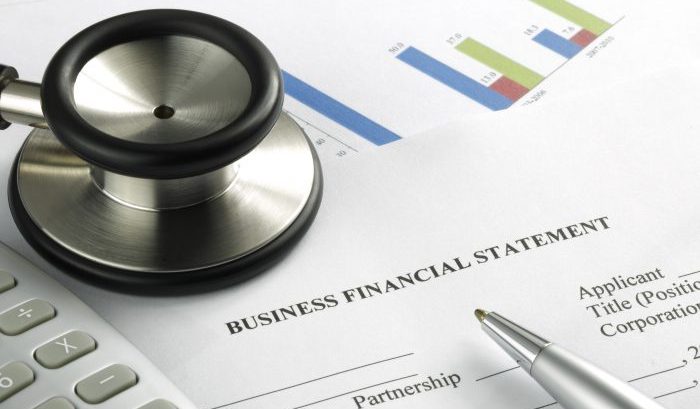 Stethoscope with financial statement, calculator, pen
