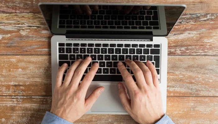 business, education, people and technology concept - close up of male hands with laptop on table